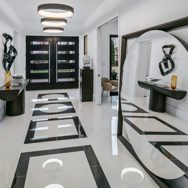 Entry with black double doors, round mirror and marble floor inlay in Urban Oasis, a custom home by Mike Stevens Homes
