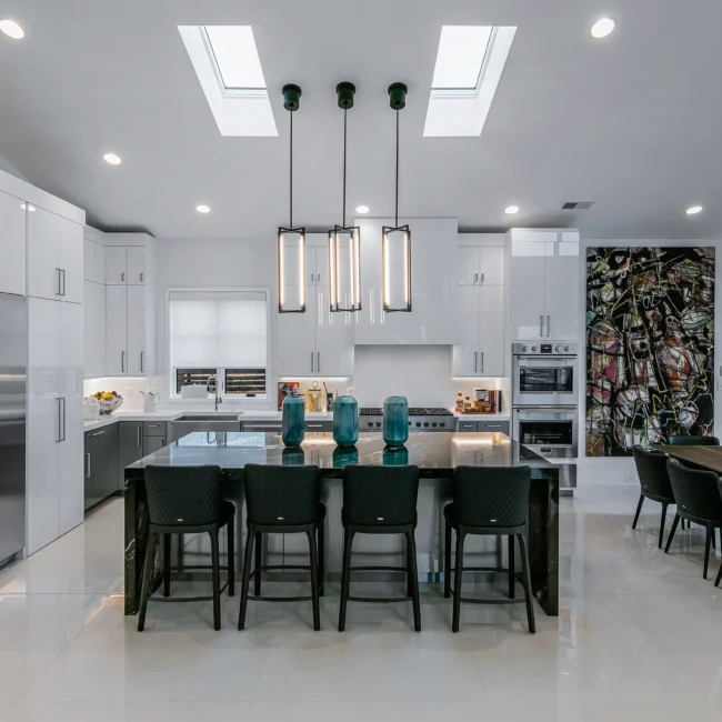 Kitchen with dark bar seating, skylights and colorful art wall in Urban Oasis by Mike Stevens Homes