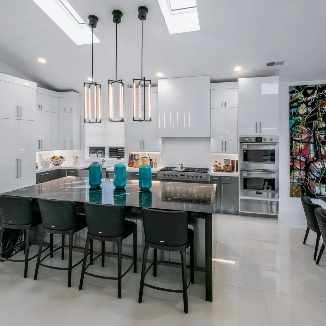Kitchen with black island, gray barstools and skylight in Urban Oasis by Mike Stevens Homes
