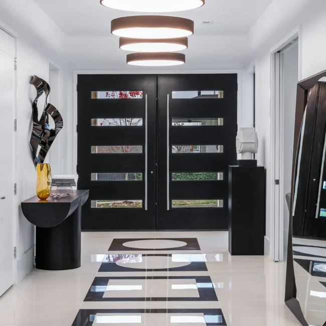 Foyer with black double front doors, round light fixture and checkered floor in Urban Oasis by Mike Stevens Homes