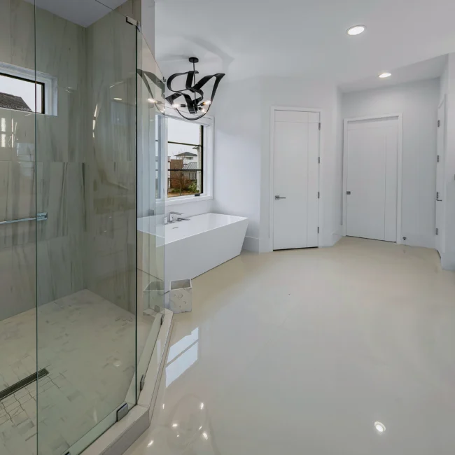 Primary bath with freestanding soaking tub and glass shower in Urban Oasis by Mike Stevens Homes