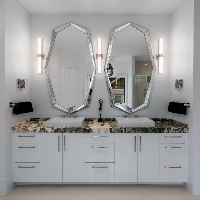 Double vanity with octagon mirrors and marble-topped white cabinets in Urban Oasis by Mike Stevens Homes
