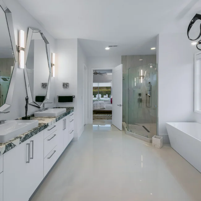 Bath with marble vanity top, dual sinks and walk-in glass shower in Urban Oasis by Mike Stevens Homes