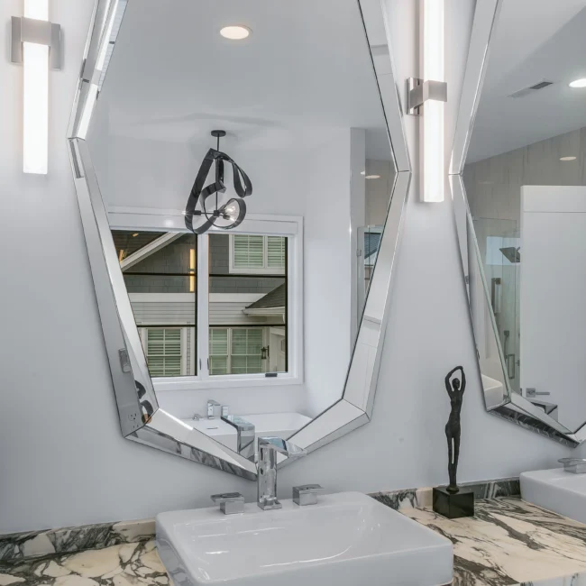 Octagon mirror above white vessel sink with marble counter in Urban Oasis by Mike Stevens Homes