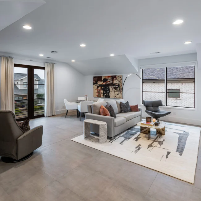 Living room with light sectional, patterned rug and wall art in Urban Oasis by Mike Stevens Homes
