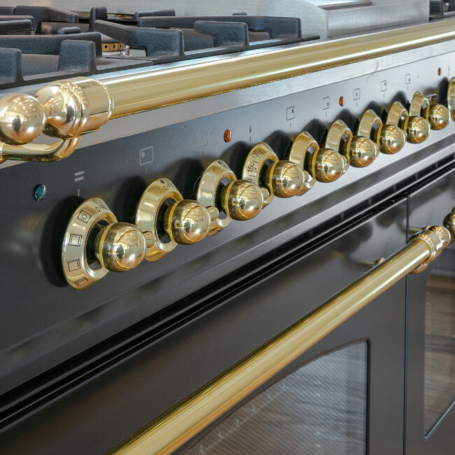 Brass-knobbed range controls on black oven door in Minimalist French Farmhouse, a custom home by Mike Stevens Homes