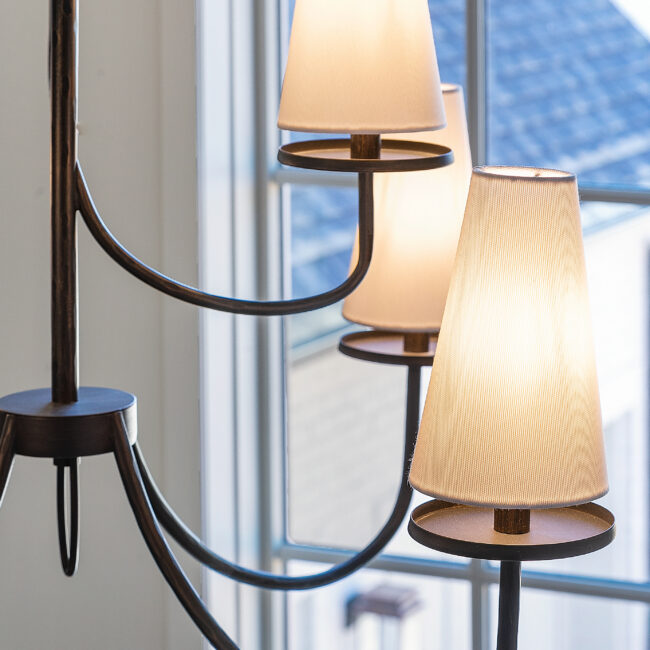 Close-up of bronze chandelier with fabric shades in Minimalist French Farmhouse, a custom home by Mike Stevens Homes