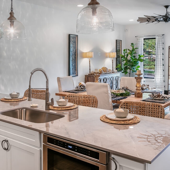 Kitchen island with undermount sink and beige quartz top in Urban Loft, a custom home by Mike Stevens Homes