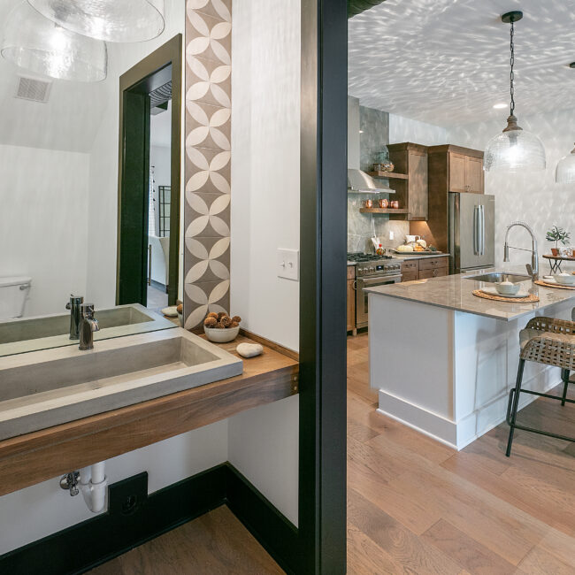 Powder room with floating vanity, vessel sink and wood counter in Urban Loft, a custom home by Mike Stevens Homes
