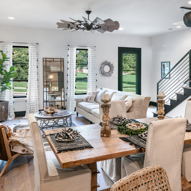 Dining area with wood table, white slipcovered chairs and windows in Urban Loft, a custom home by Mike Stevens Homes