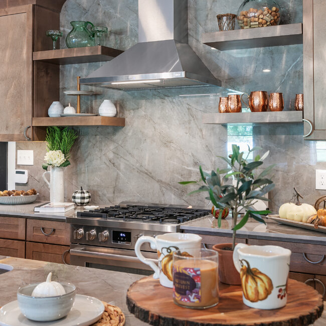 Kitchen with gray marble backsplash, floating shelves and copper accents in Urban Loft, a custom home by Mike Stevens Homes