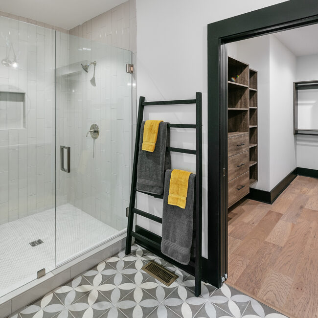 Walk-in shower with glass door, towel ladder and built-in niche in Urban Loft, a custom home by Mike Stevens Homes