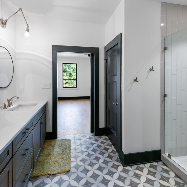 Bathroom vanity with dark cabinets and patterned tile floor in Urban Loft, a custom home by Mike Stevens Homes