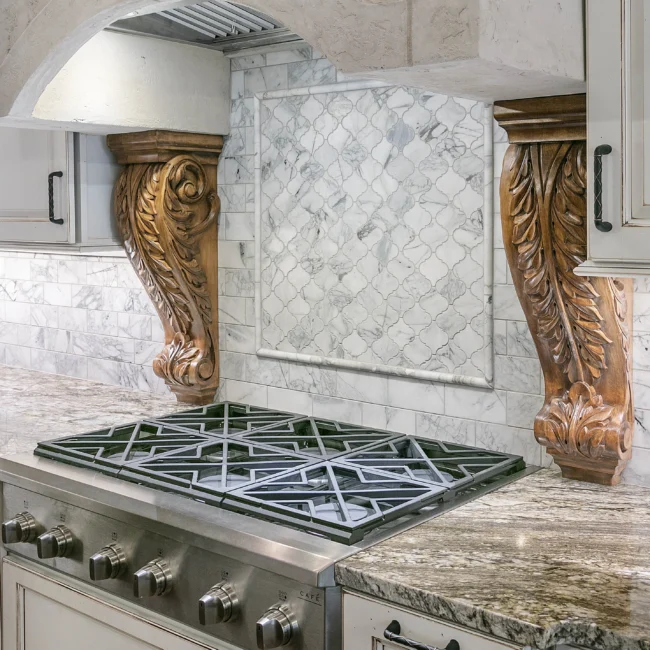 Range with marble tile backsplash and carved wood corbels in European Villa, a custom home by Mike Stevens Homes