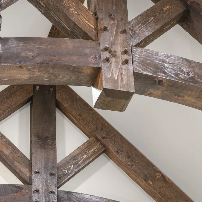 Close-up of exposed rough-hewn timber beams and bolted joints in European Villa, a custom home by Mike Stevens Homes
