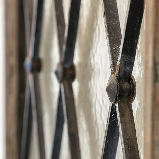 Close-up of wrought iron lattice panel in glass door in European Villa, a custom home by Mike Stevens Homes