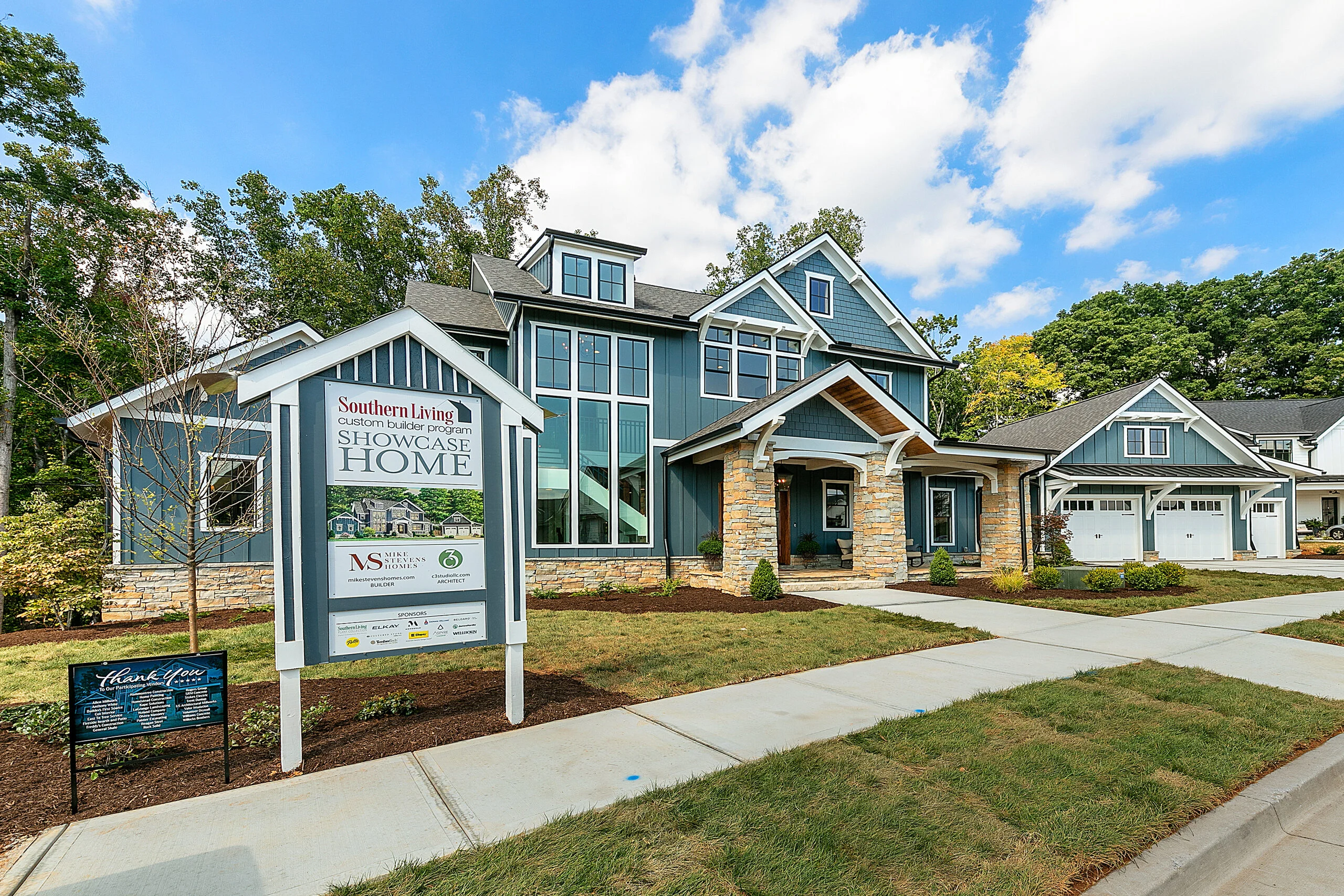 Blue craftsman exterior with stone porch columns in Southern Belle, a custom home by Mike Stevens Homes