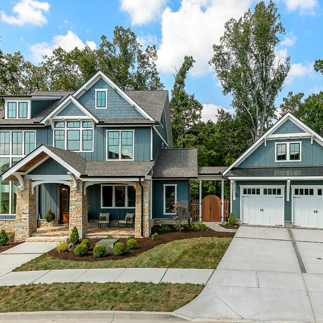 Blue-gray two-story home with side-load garage and driveway in Southern Belle, a custom home by Mike Stevens Homes