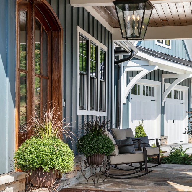 Rocking chair and potted plants on covered porch in Southern Belle, a custom home by Mike Stevens Homes