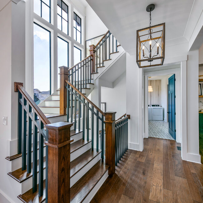 Staircase with dark iron balusters and wood newel post in Southern Belle, a custom home by Mike Stevens Homes