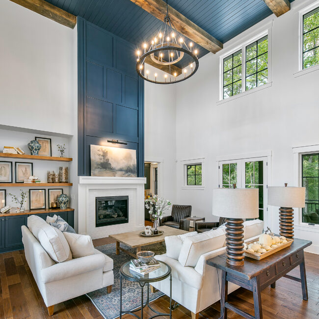 Two-story great room with fireplace, built-in shelves and white sofas in Southern Belle, a custom home by Mike Stevens Homes