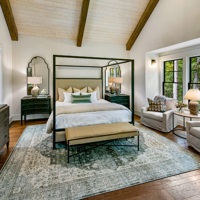 Primary bedroom with canopy bed, upholstered bench and beamed ceiling in Southern Belle, a custom home by Mike Stevens Homes