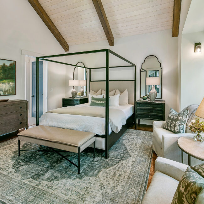 Canopy bed with cream bedding and teal rug in Southern Belle, a custom home by Mike Stevens Homes