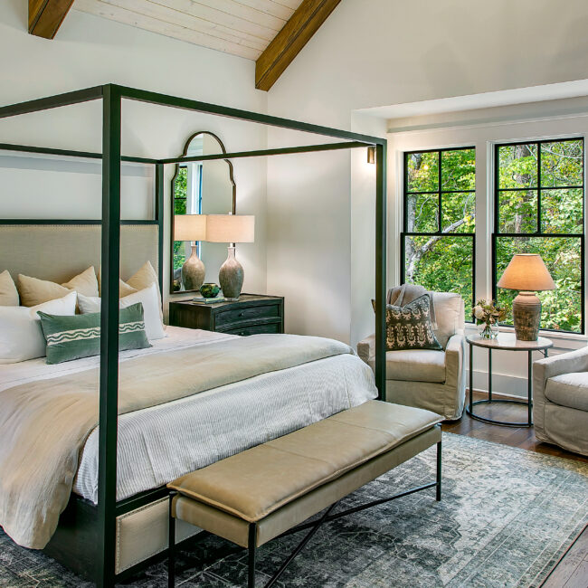 Canopy bed with wood ceiling beams and tree-view windows in Southern Belle, a custom home by Mike Stevens Homes