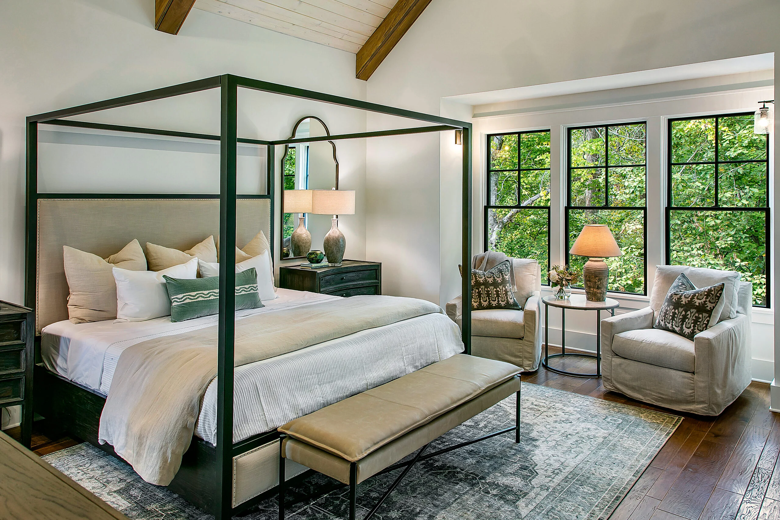 Canopy bed with wood ceiling beams and tree-view windows in Southern Belle, a custom home by Mike Stevens Homes