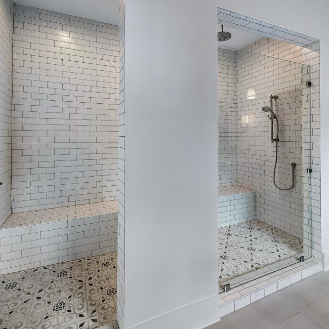 Walk-in shower with subway tile, patterned floor and tile bench in Southern Belle, a custom home by Mike Stevens Homes