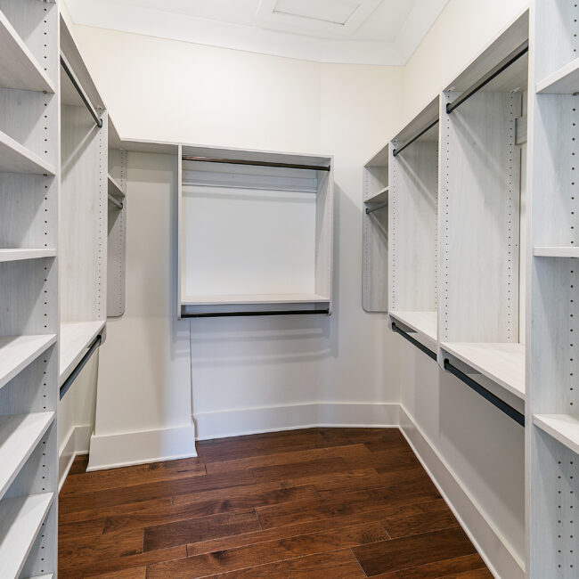 Walk-in closet with white built-in shelving in Southern Belle, a custom home by Mike Stevens Homes