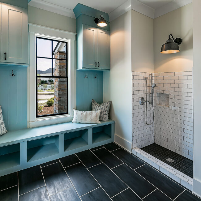 Mudroom with teal lockers, built-in bench and walk-in shower in Southern Belle, a custom home by Mike Stevens Homes