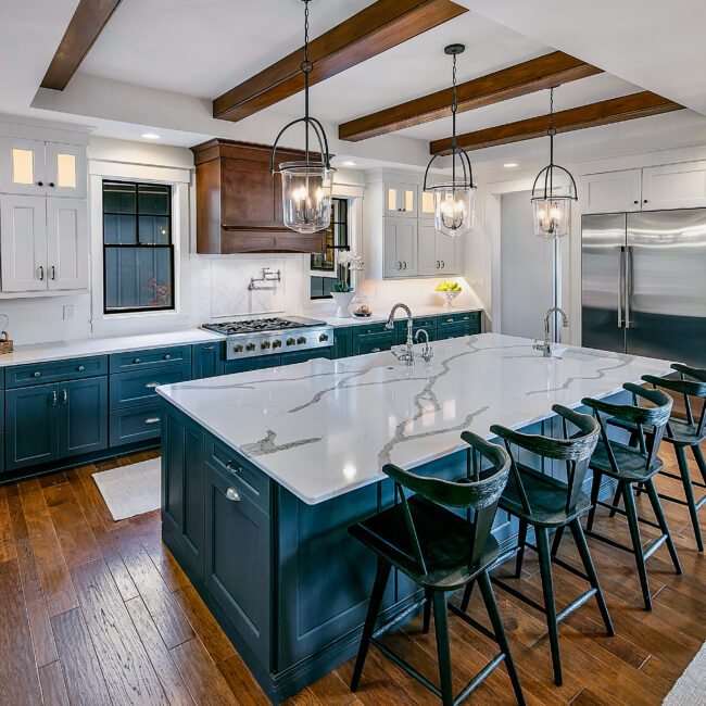Kitchen island with white quartz top and black bar stools in Southern Belle, a custom home by Mike Stevens Homes