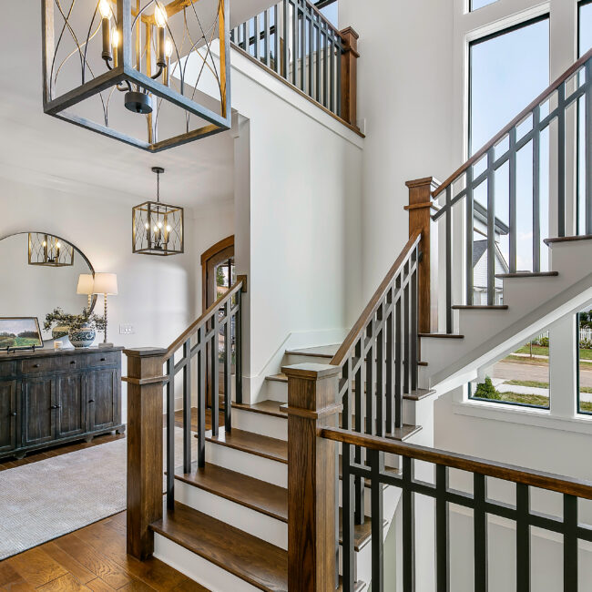 Open staircase with wood rail and iron spindles in Southern Belle, a custom home by Mike Stevens Homes
