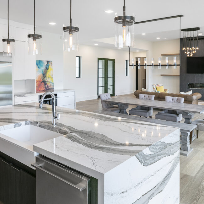 Open kitchen with farmhouse sink and living area beyond in Rocky Top Hideaway, a custom home by Mike Stevens Homes