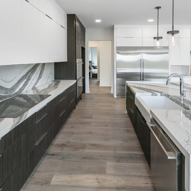Galley-style kitchen with stainless refrigerator in Rocky Top Hideaway, a custom home by Mike Stevens Homes