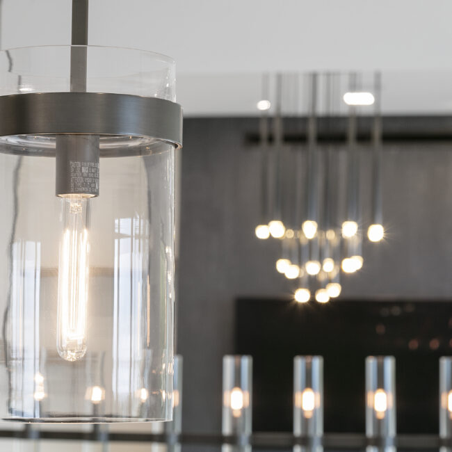 Glass-cylinder pendant chandelier over dining room in Rocky Top Hideaway, a custom home by Mike Stevens Homes
