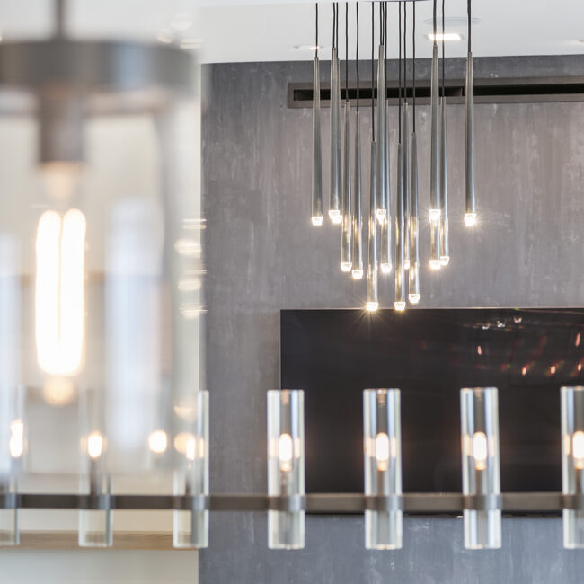 Tapered black pendant lights in front of dark accent wall in Rocky Top Hideaway, a custom home by Mike Stevens Homes