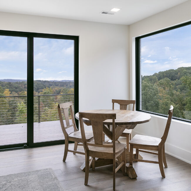 Breakfast nook with round wood table by sliding doors in Rocky Top Hideaway, a custom home by Mike Stevens Homes