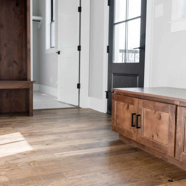 Mudroom with wood bench and wood cabinet in Rural Farmhouse, a custom home by Mike Stevens Homes