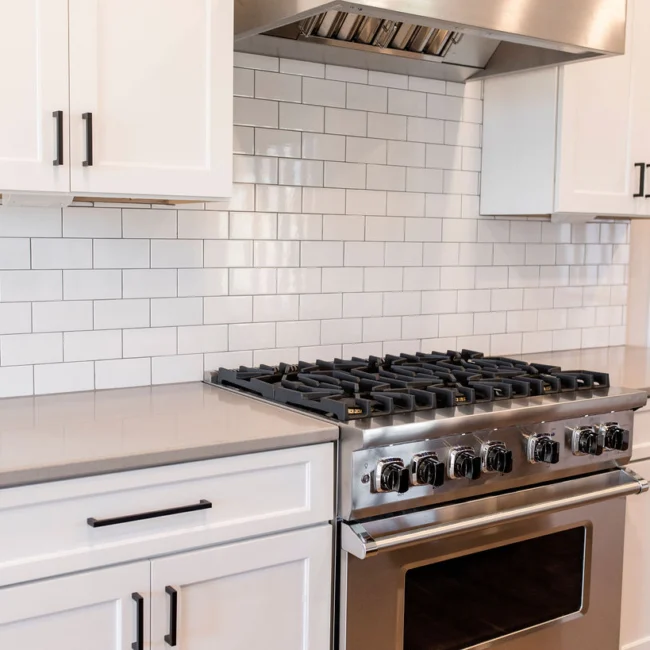 Kitchen with subway tile backsplash and gas range in Rural Farmhouse, a custom home by Mike Stevens Homes