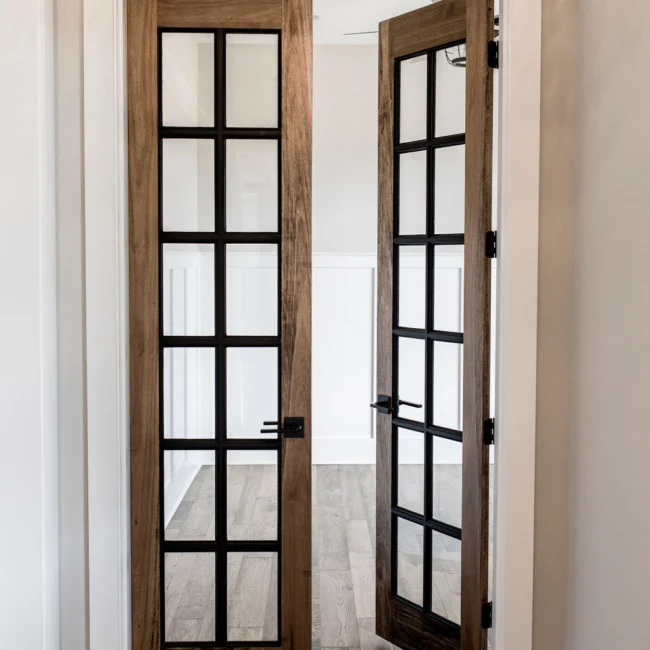 Pair of black-framed French doors with divided glass in Rural Farmhouse, a custom home by Mike Stevens Homes