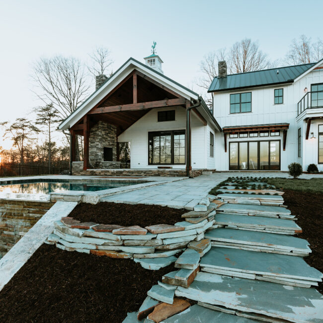 Flagstone path leading past stone garden bed toward pool in Mountain Vista by Mike Stevens Homes