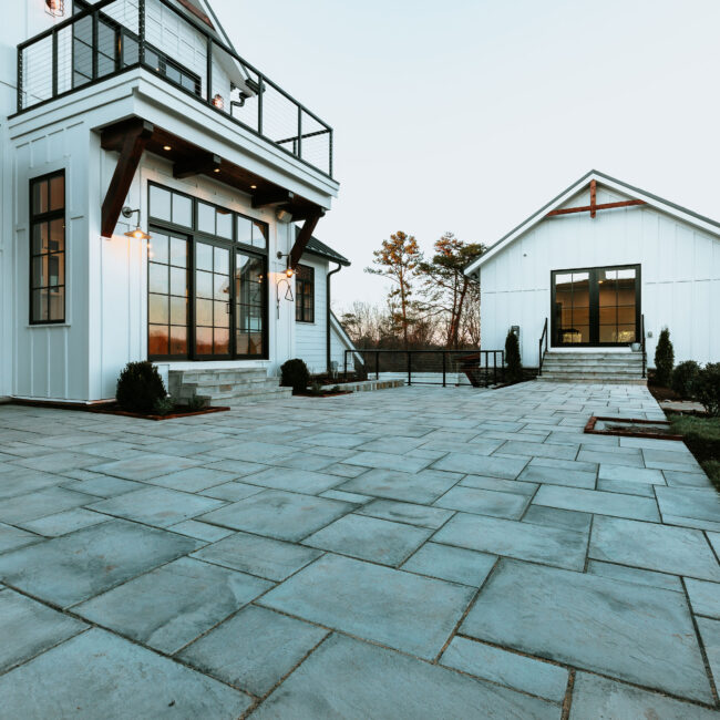 Flagstone patio and white home with black-framed French doors in Mountain Vista by Mike Stevens Homes