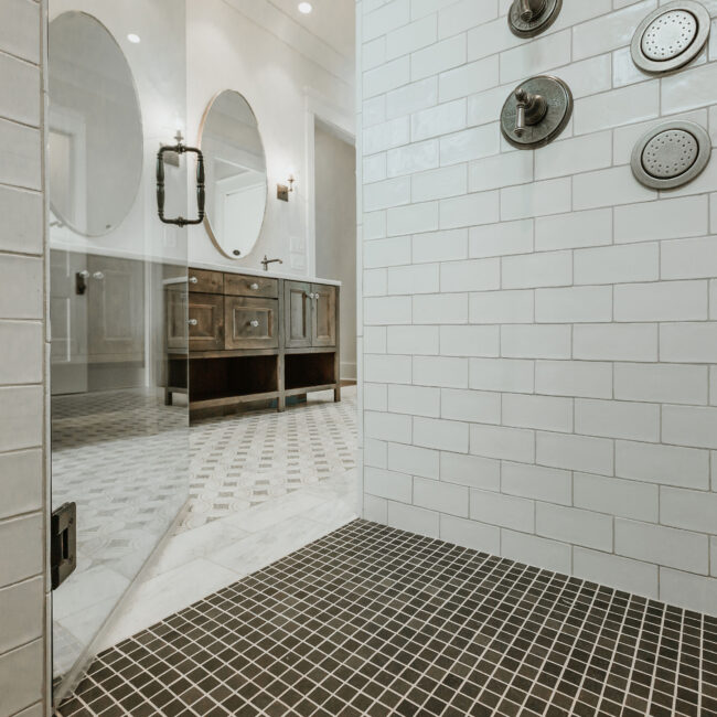 View from shower into bathroom with wood vanity and marble floor in Mountain Vista by Mike Stevens Homes