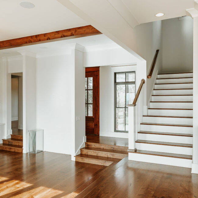 Entry staircase with white railings and wood-stained treads in Mountain Vista by Mike Stevens Homes