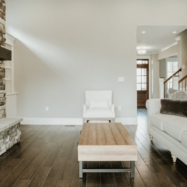 Living room with white armchair and wood coffee table in Timeless Charm, a custom home by Mike Stevens Homes