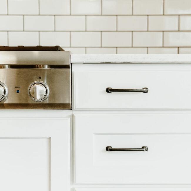 Close-up of range and white drawers with bar pulls in Timeless Charm, a custom home by Mike Stevens Homes