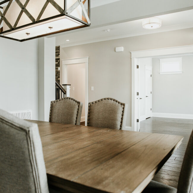 Dining room with wood table and nailhead chairs in Timeless Charm, a custom home by Mike Stevens Homes