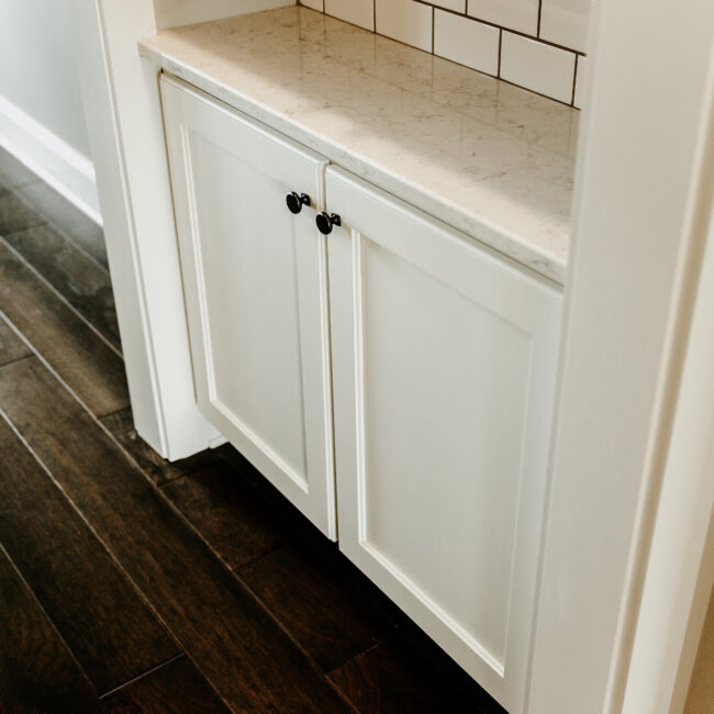 Close-up of white cabinetry with black knobs in Timeless Charm, a custom home by Mike Stevens Homes